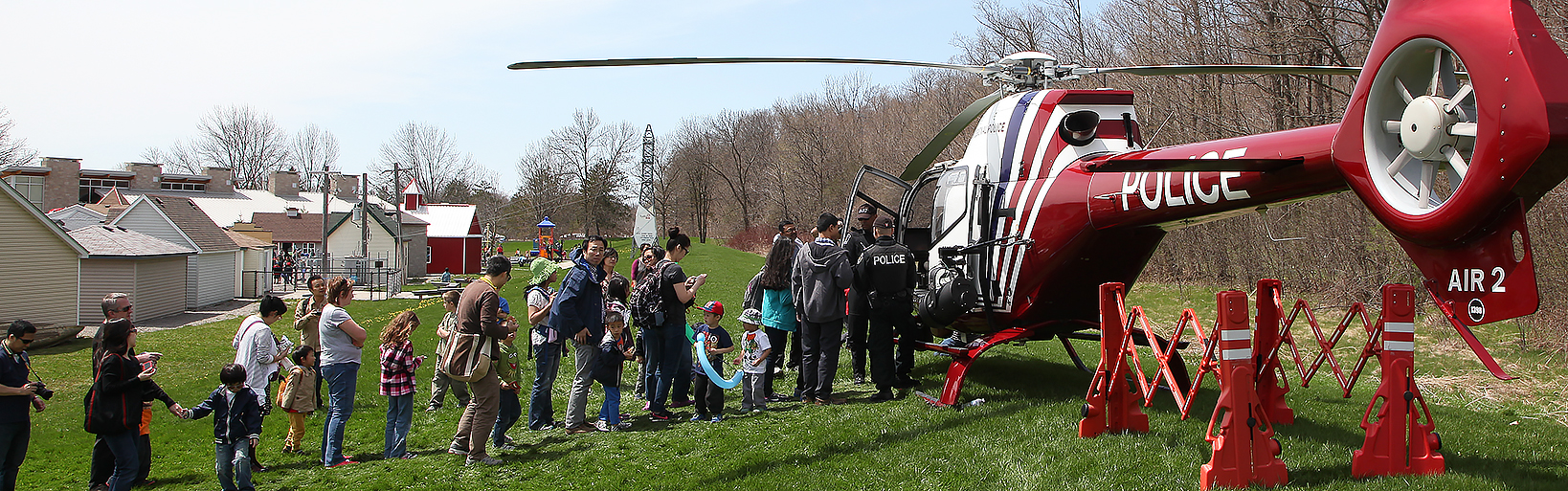A group of people line up beside a helicopter