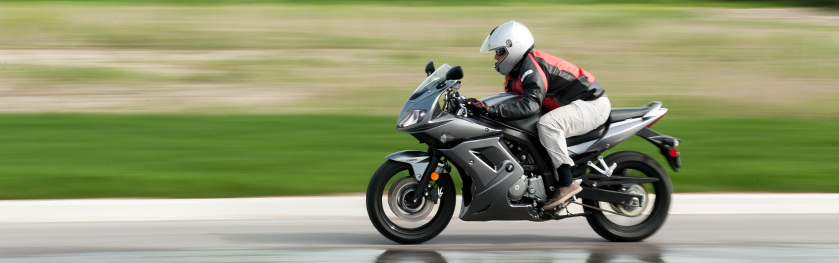 A man on a silver motorcycle speeding