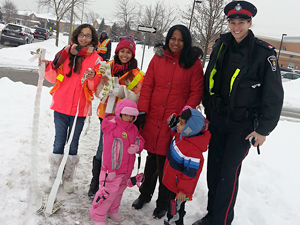 An officer stands with children smiling