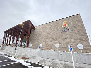 A building with a grey stone wall and wood facade.