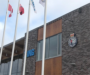 A brown-bricked building with a police crest on the wall