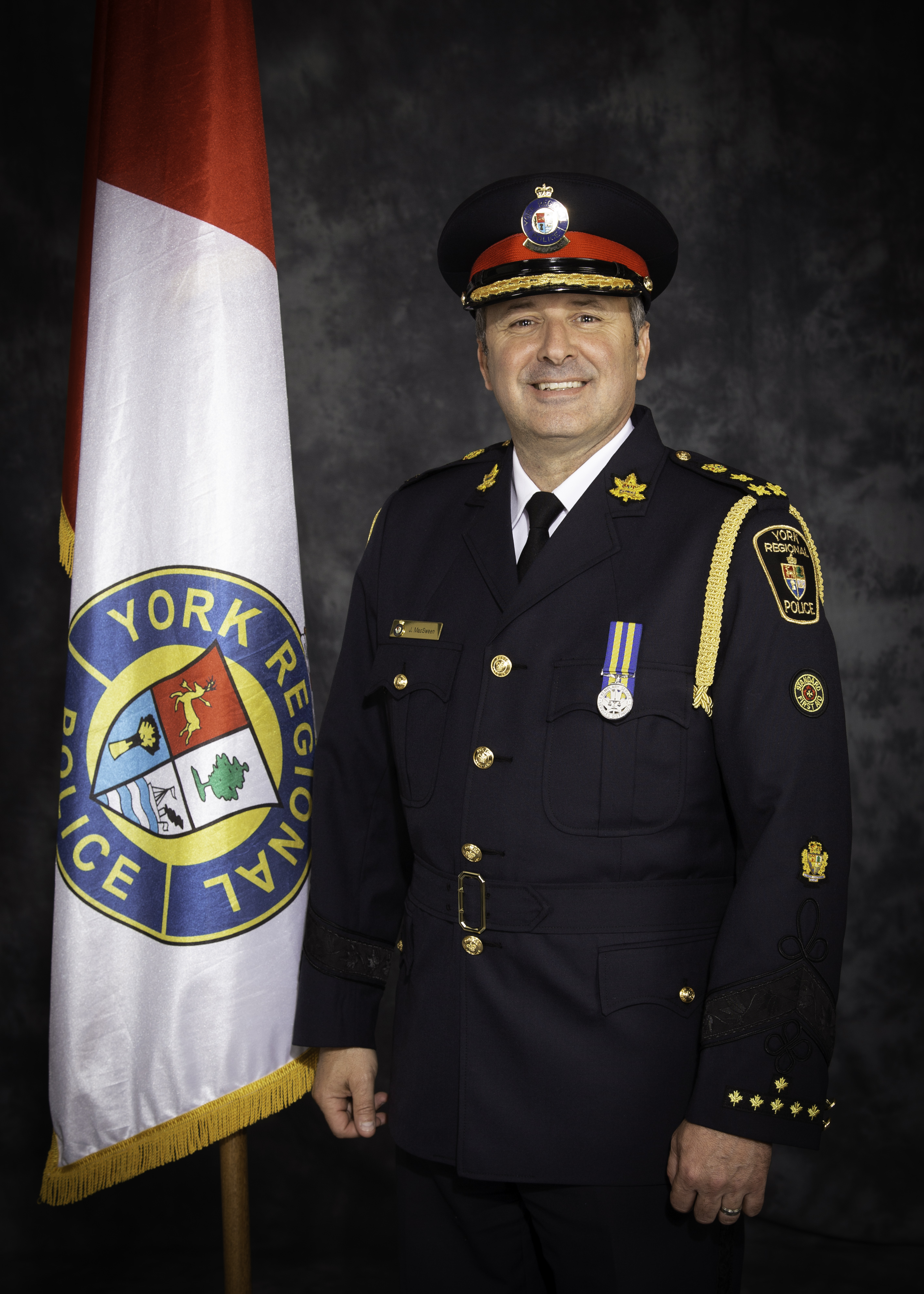 A man in a police uniform smiles