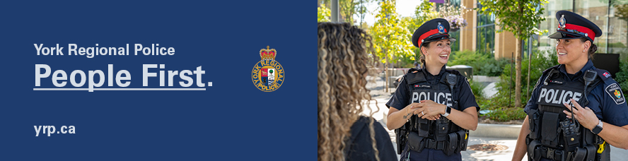 Two female officers chatting with a woman who's back is turned to the camera
