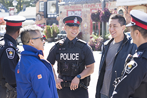 A man smiles in a police uniform in a group of people