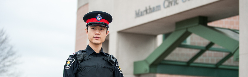 An officer stands in front of a police station