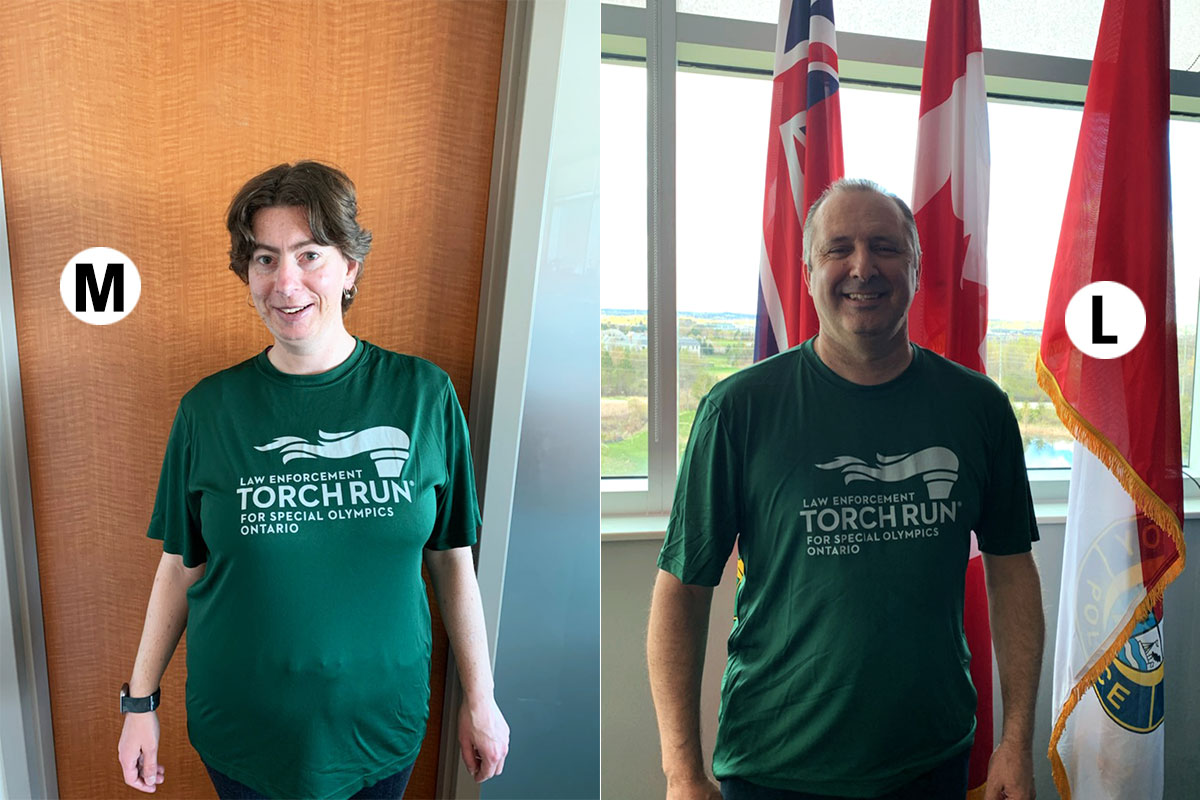 A female Special Olympic athlete and a male police officer in green Torch Run T-shirts