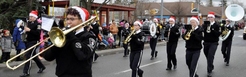 A group of teens playing instruments marching in the Santa Claus parade