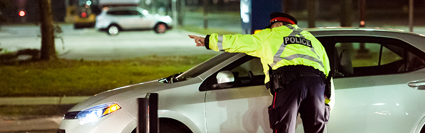 Photo of officer pointing with car in background