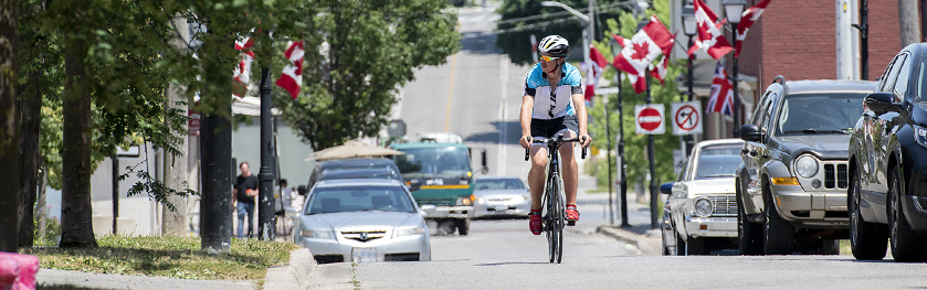 A man on a bicycle rides down a crowded urban street