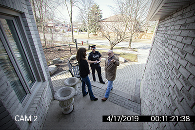 A man and a woman speak to a man in a police uniform