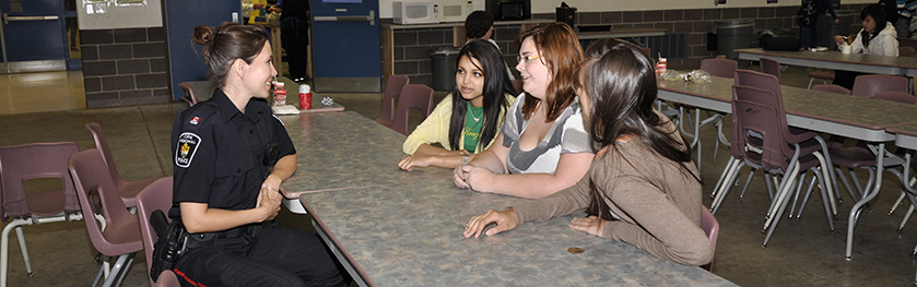 Officer talking to teens at school