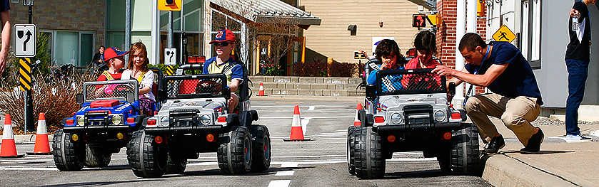 A group of kids in small cars 