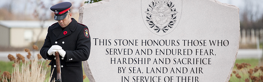 An officer stands with head bowed