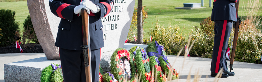 Two officers stand in front of a monument