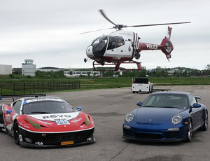 A helicopter flies over two vehicles