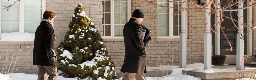 Two officers in plain clothes walking to a house