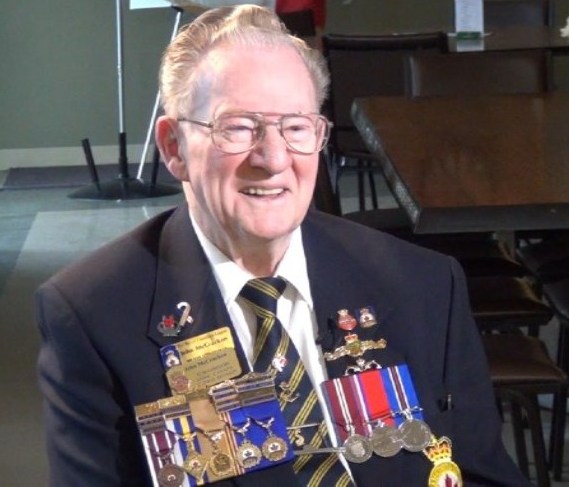 A man sits with medals 