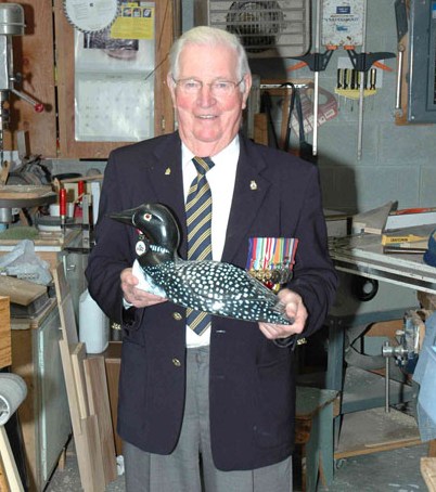 A man in a blazer holds a loon bank
