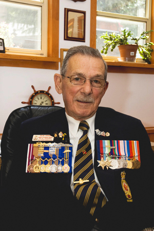 A man wears two rows of medals on his chest