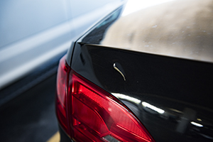 A large dent and scratch on a black car