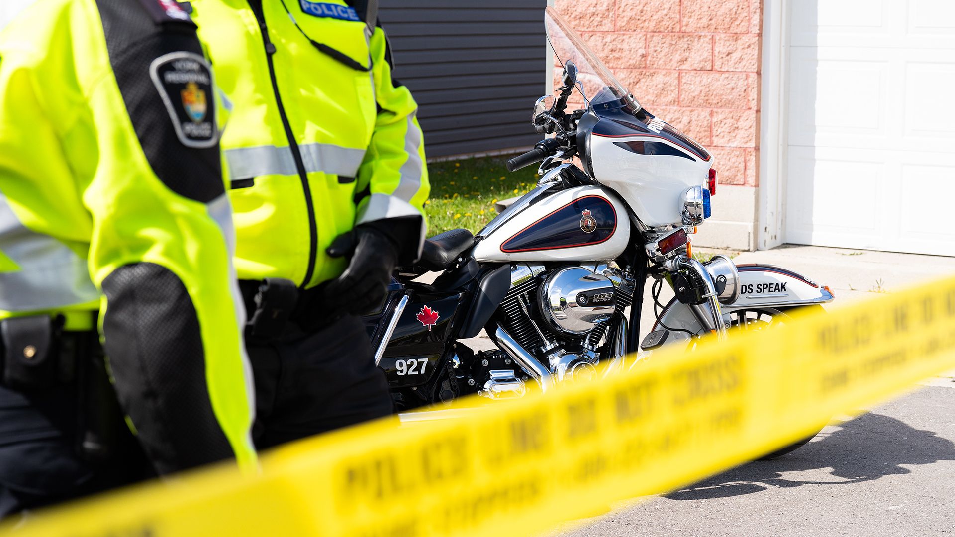 Police tape with officers in reflective jackets and motorcycle.
