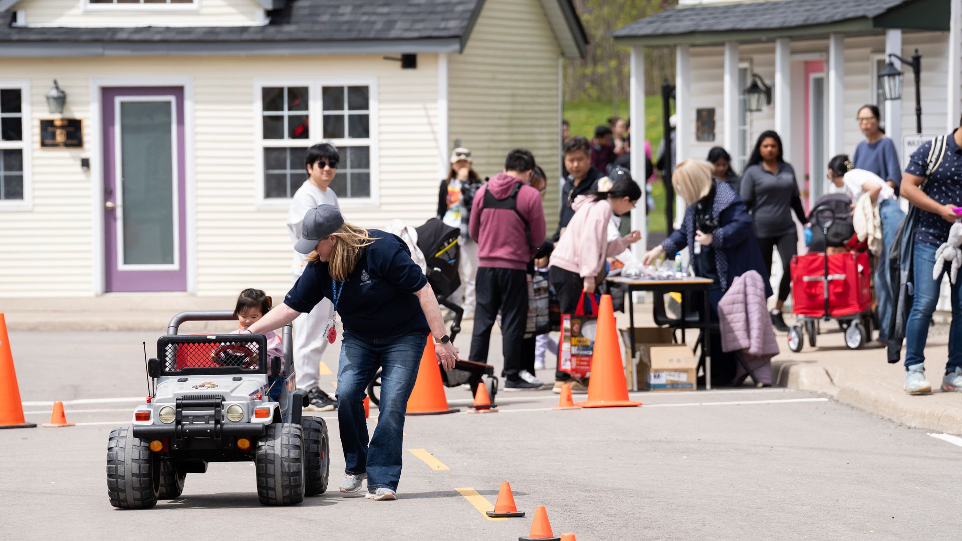 A woman guides a child in a miniature car