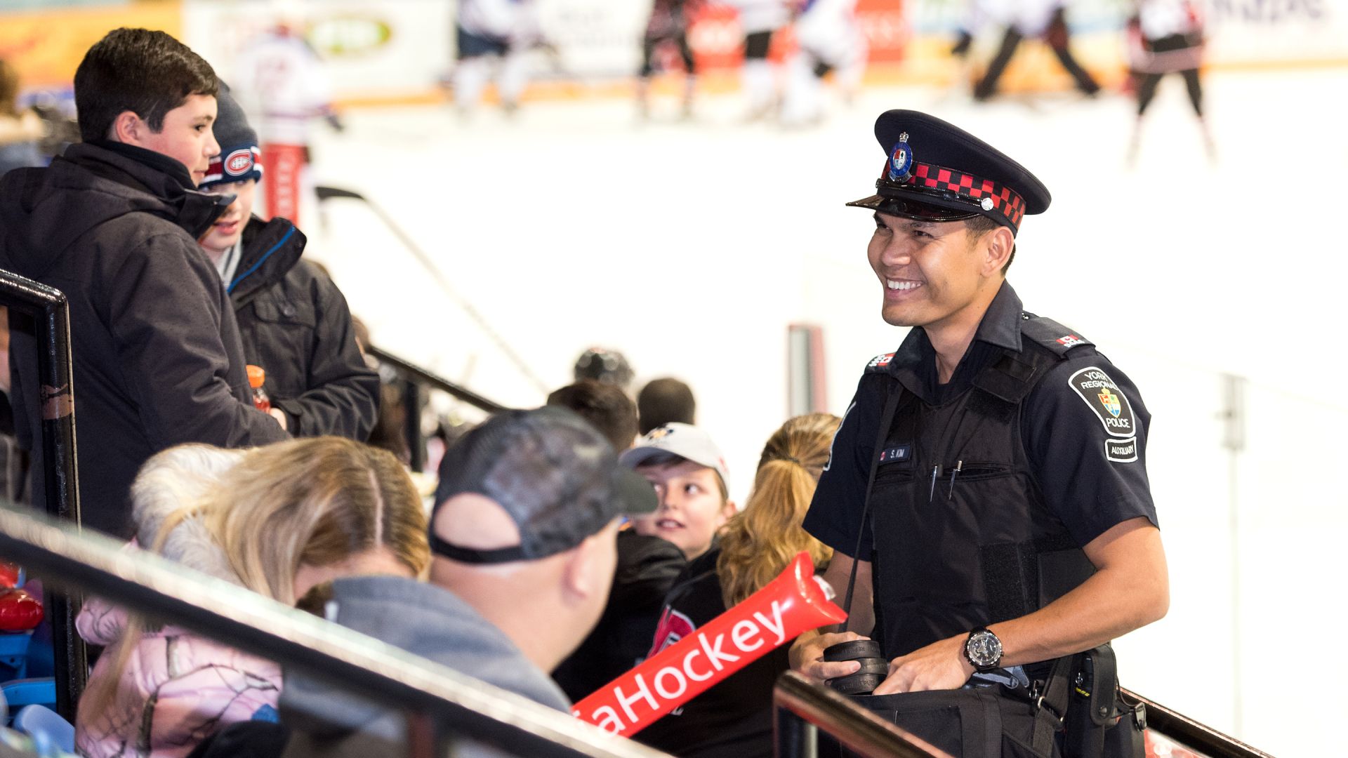 A man in a uniform smiles inside an arena