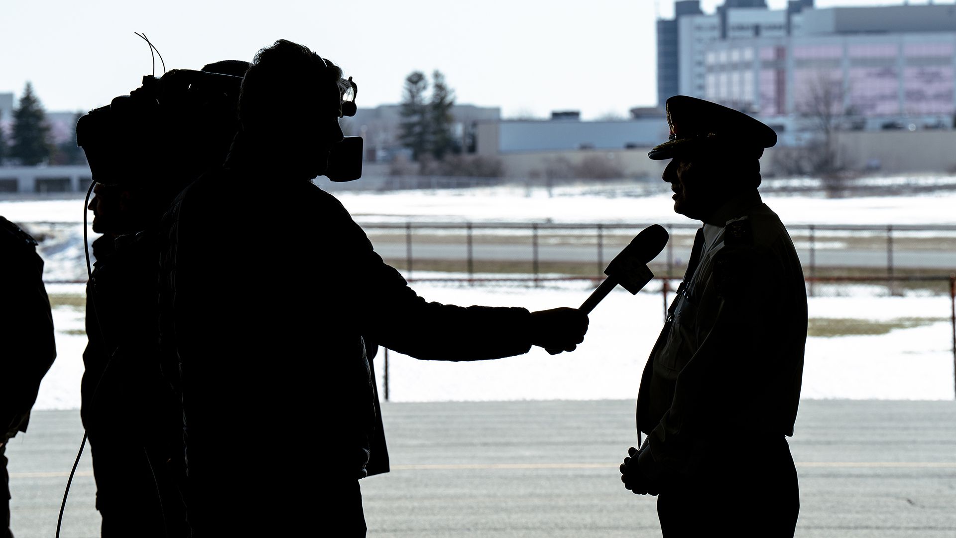 A silhouette shows Chief MacSween speaking to a camera operator.