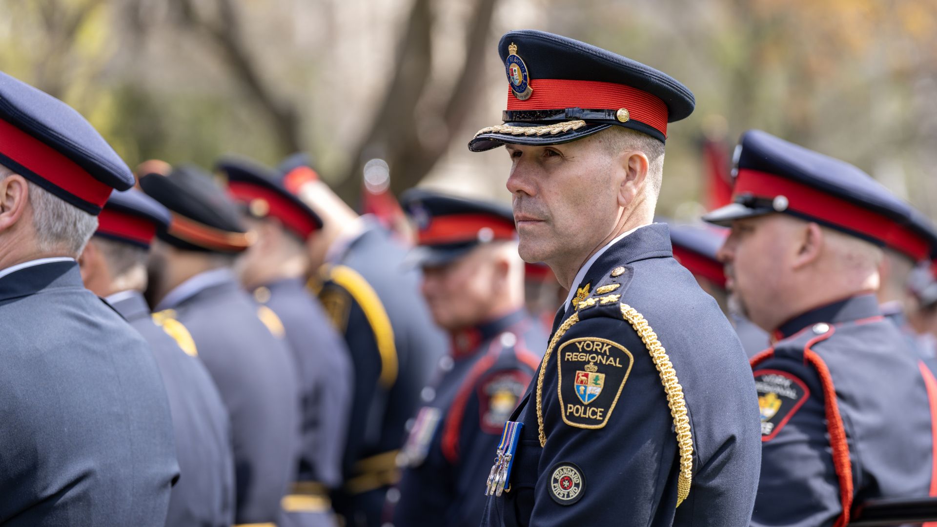 A man in a police uniform looks through a crowd