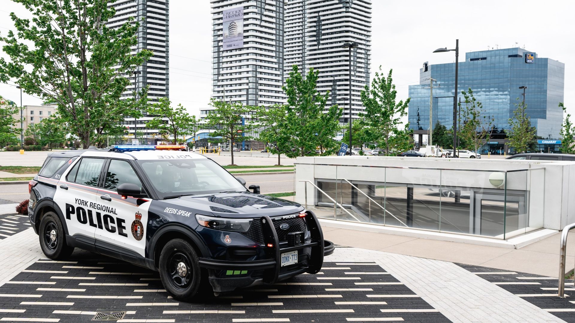 A police cruiser in front of large buildings