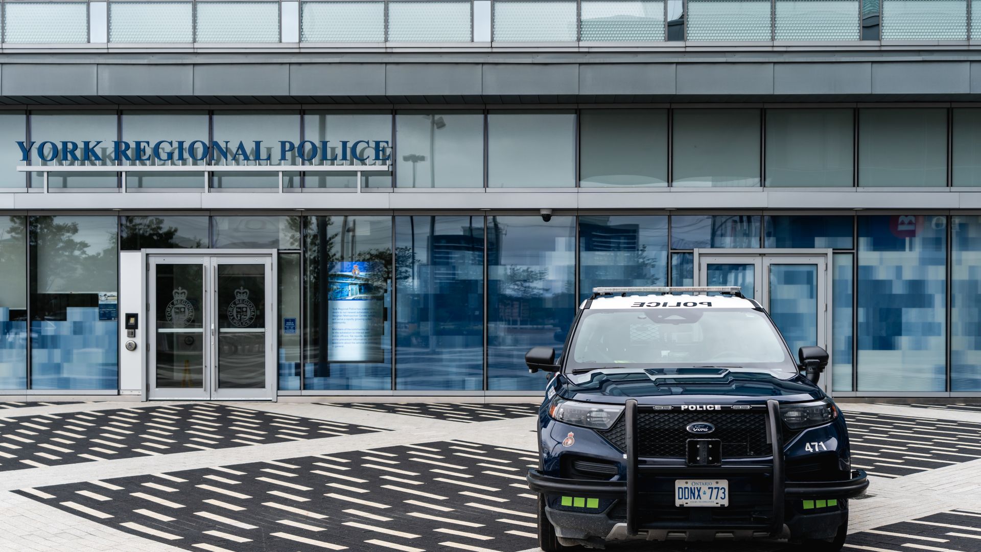 A police vehicle is parked in front of a building that reads YORK REGIONAL POLICE