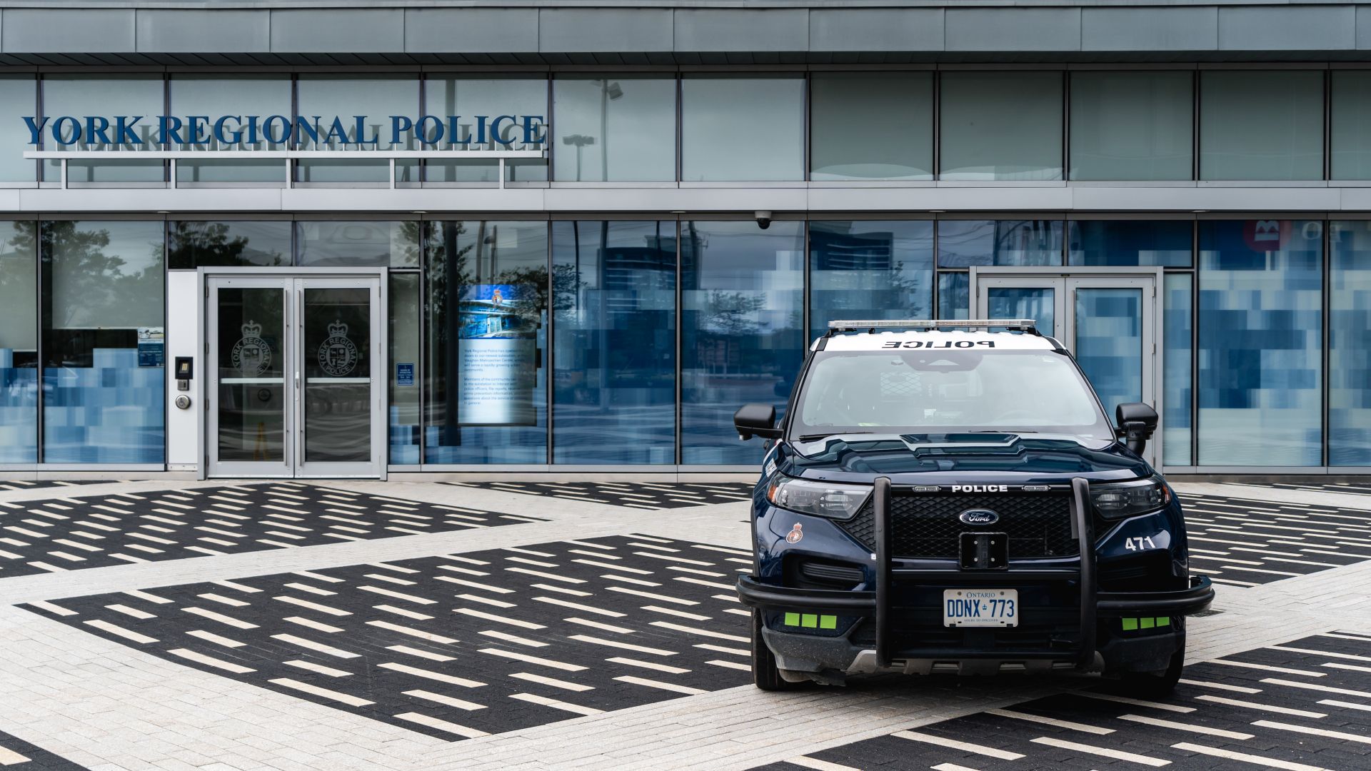 A police vehicle is parked in front of a building that reads YORK REGIONAL POLICE