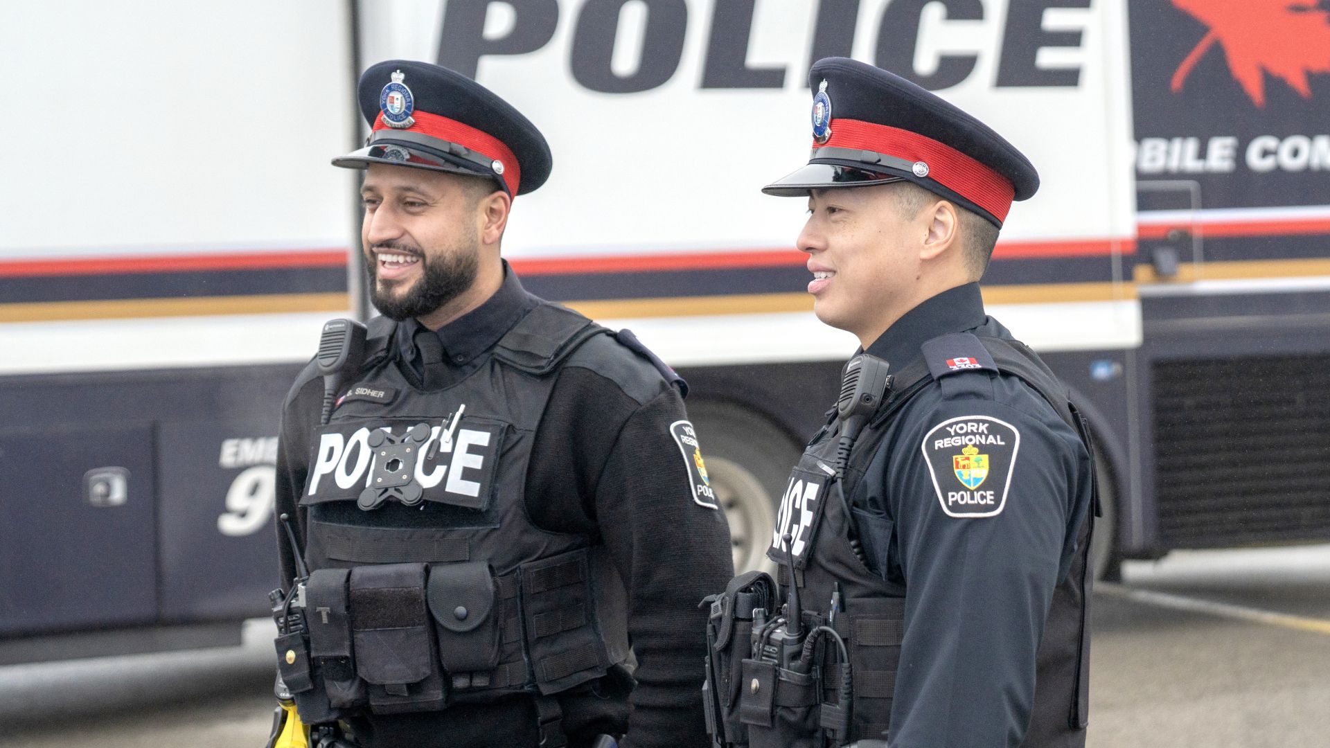 Two men in uniforms smile
