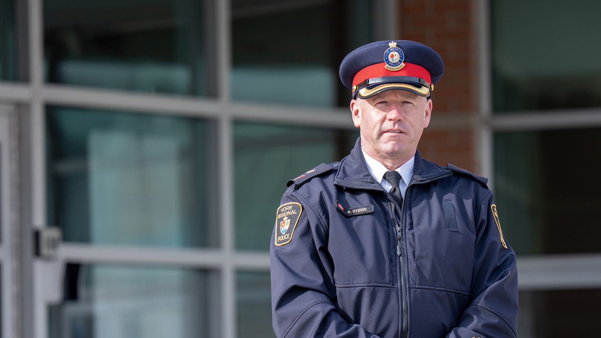 A man in a police uniform in front of a building
