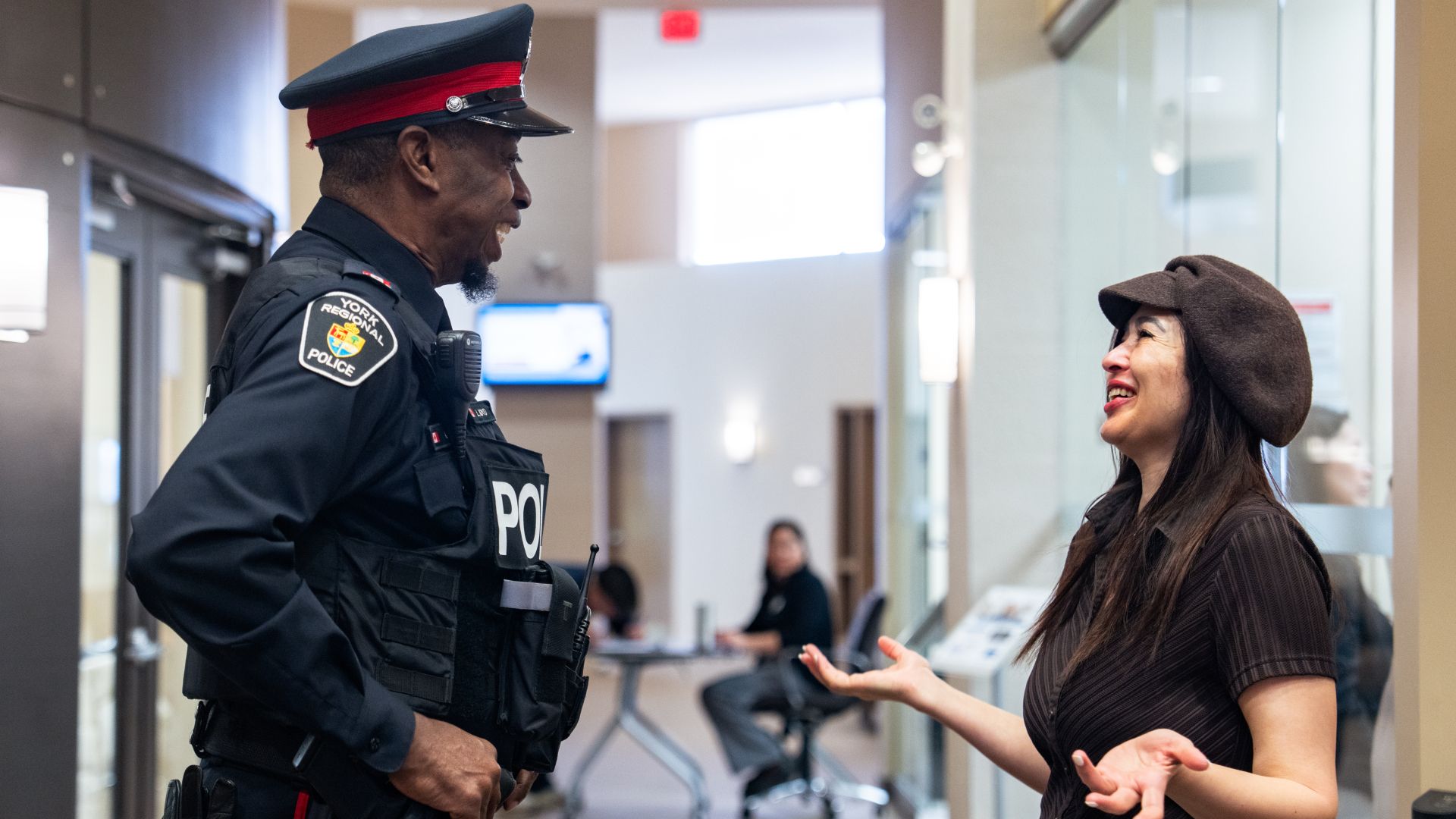 A man in a police uniform speaks to a woman