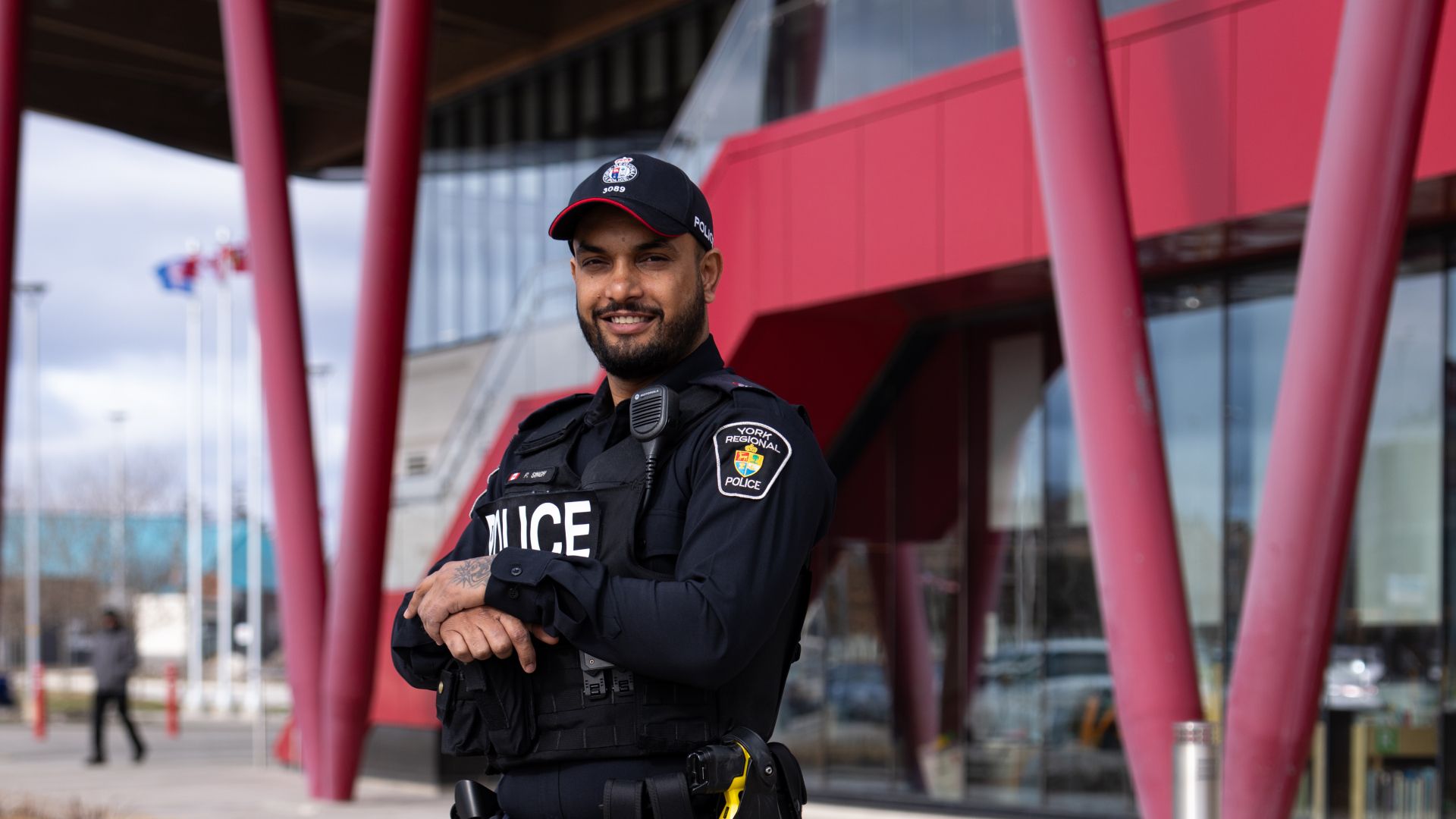 A police officer stands in front of a community center entrance