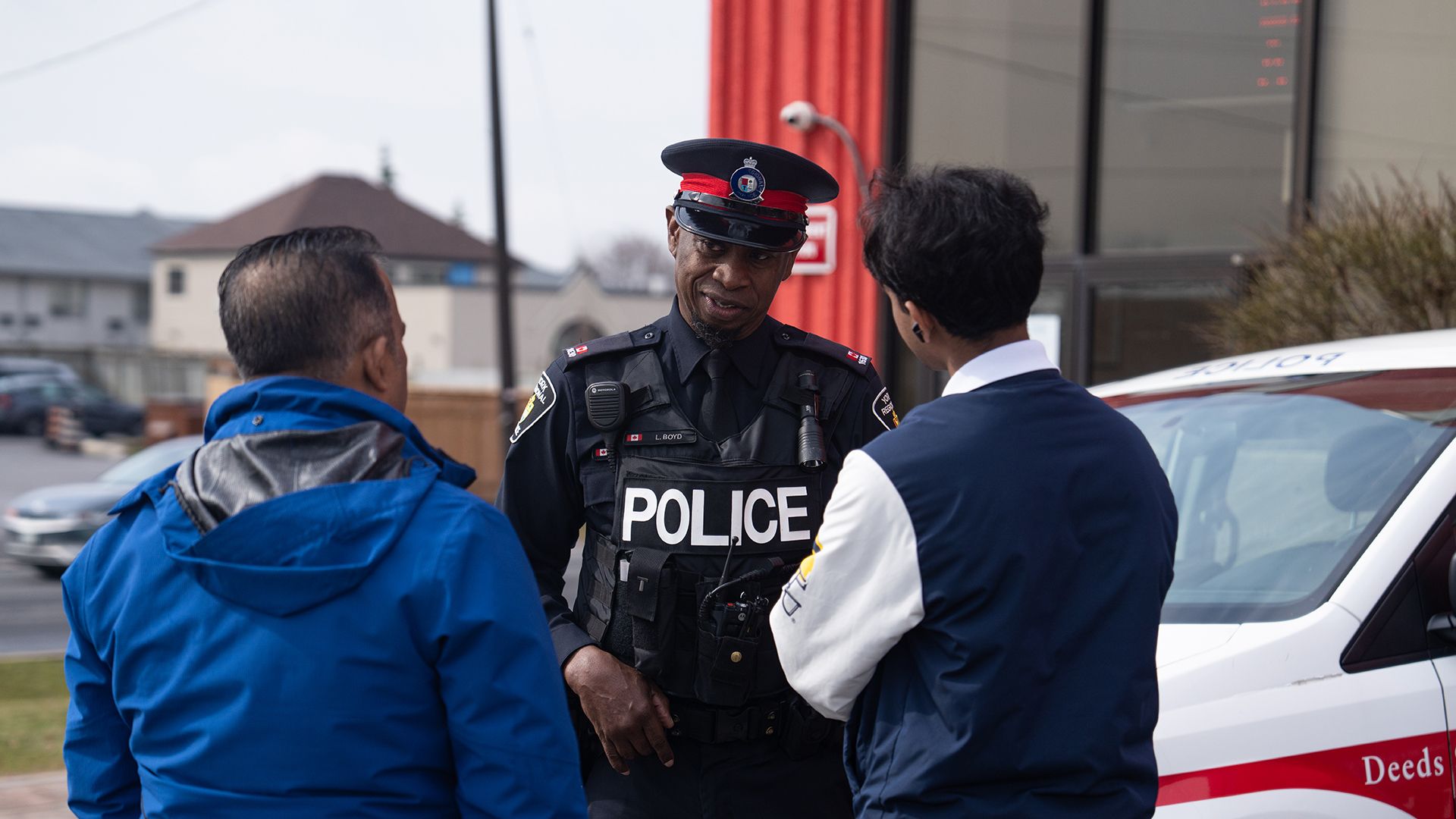 An officer speaks with a man and his teenage son