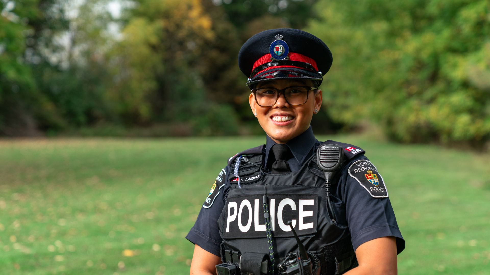 A woman in a police uniform smiles