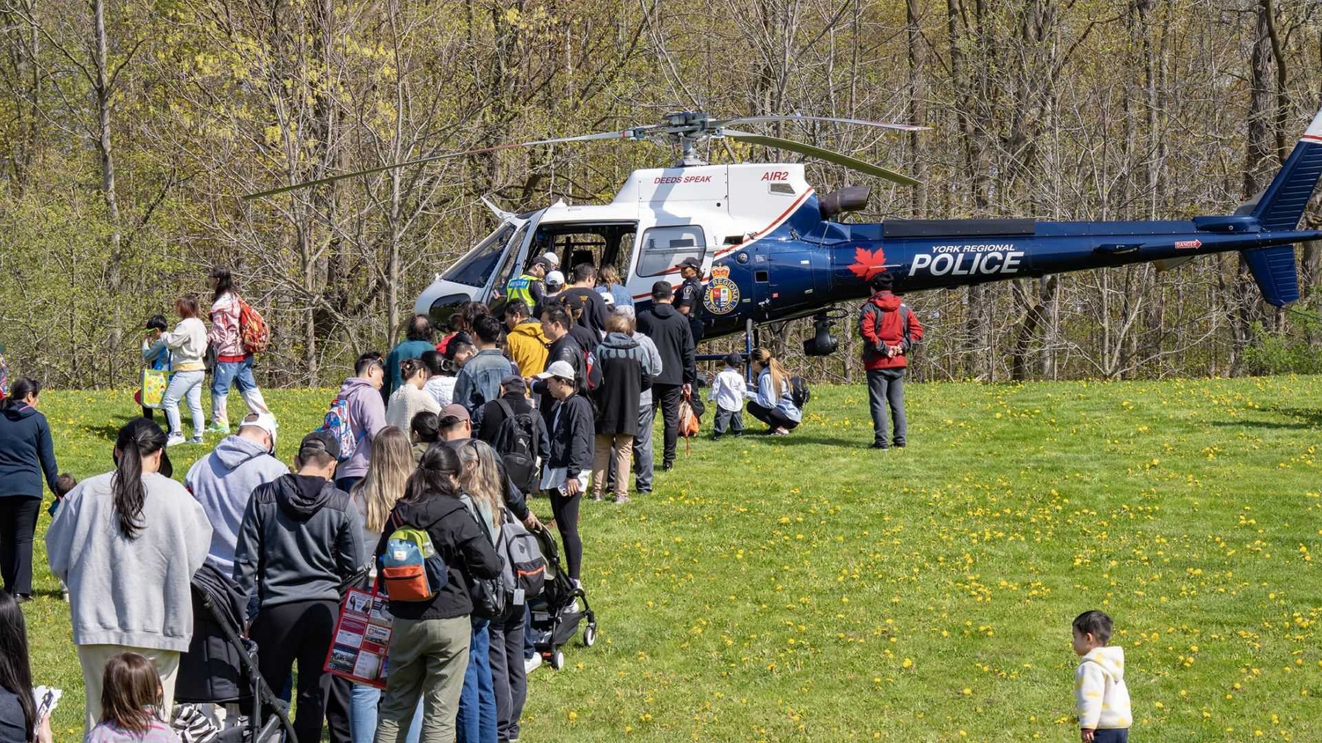 A line of people next to a police helicopter