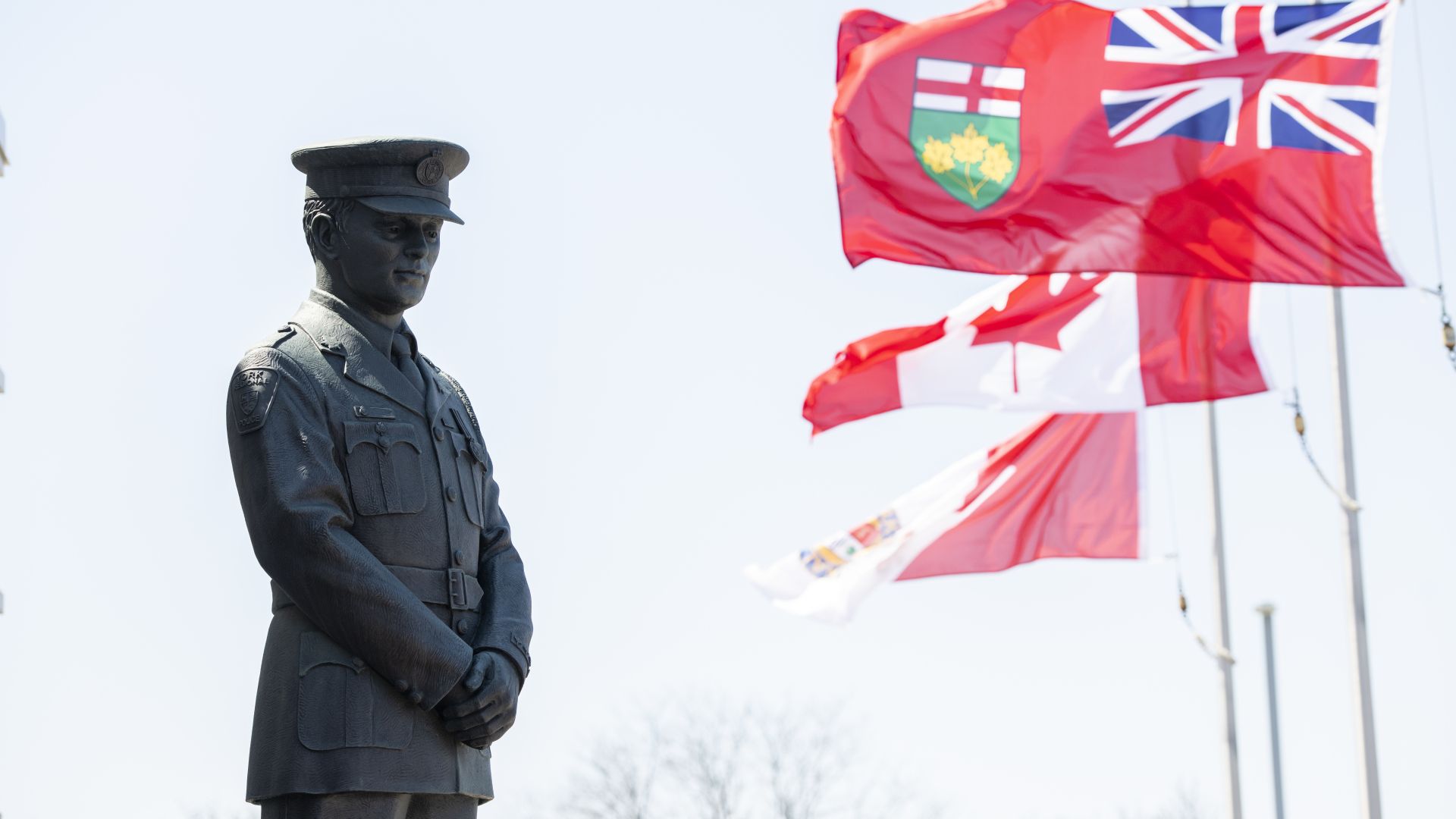 A statue of a police officer next to a flag
