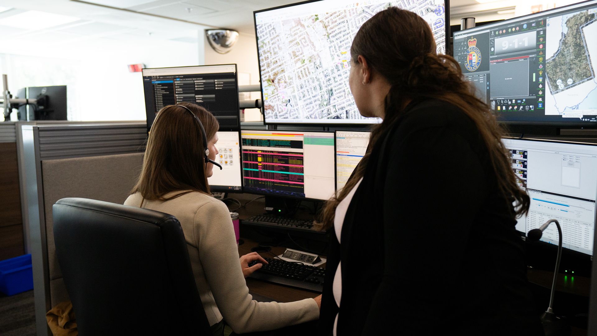 Two people look at a computer workstation