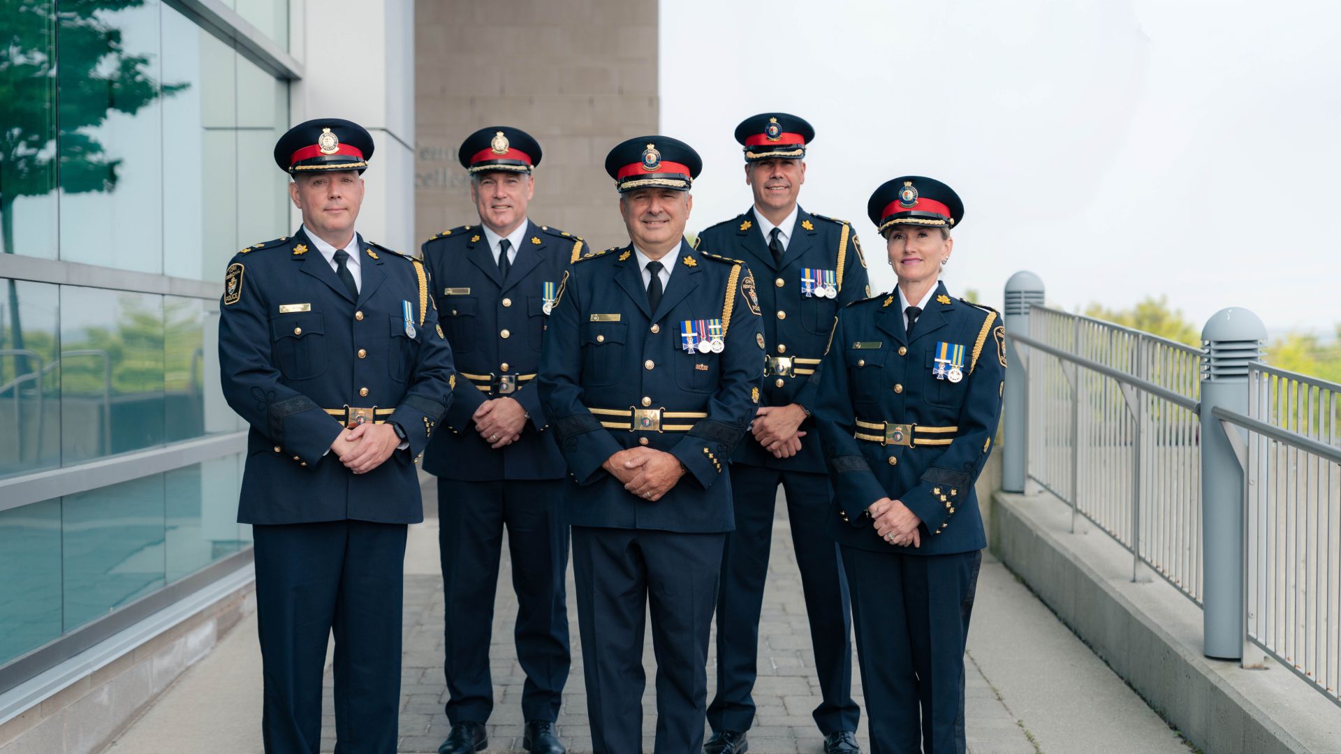 A group of five people in formal police uniforms