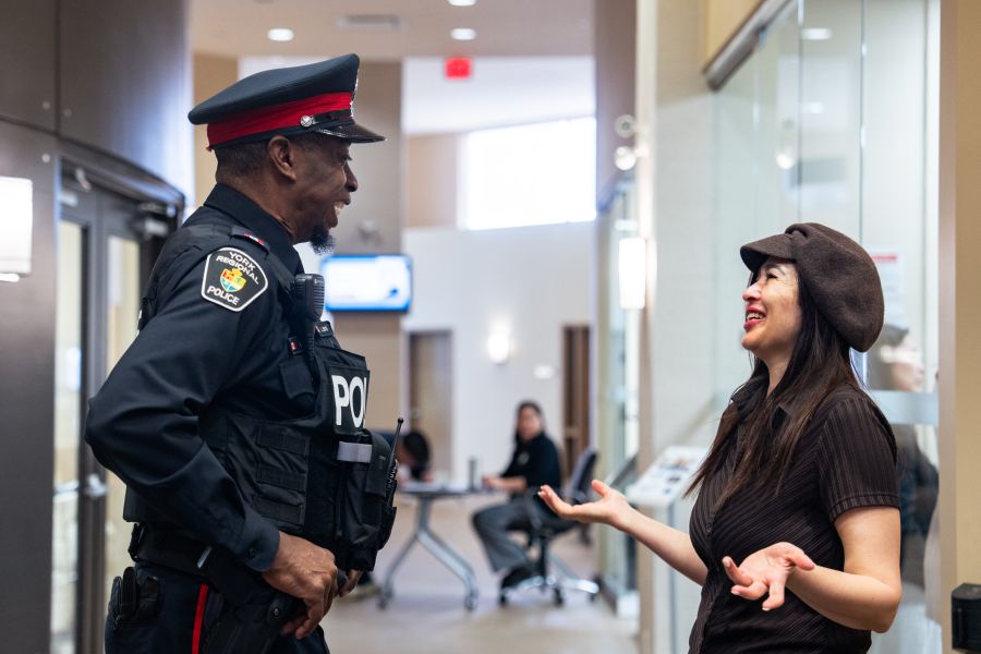 Police officer laughing with a civilian woman inside.