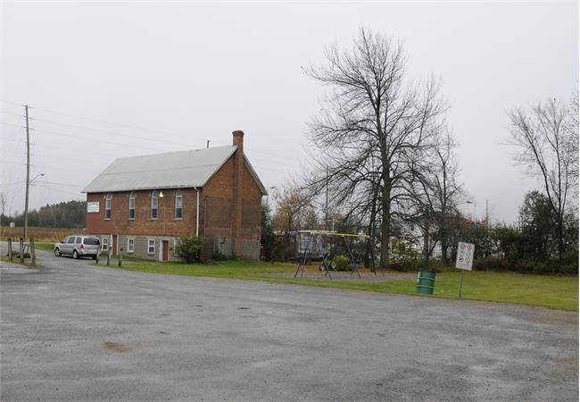A red brick building and a blue and yellow swingset