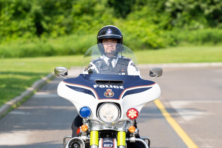 An officer drives a motorcycle on an empty road