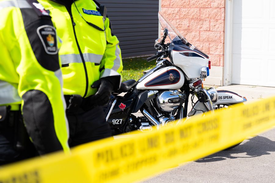 Police tape with officers in reflective jackets and motorcycle.