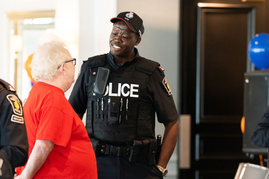 Police officer speaking with elderly man.