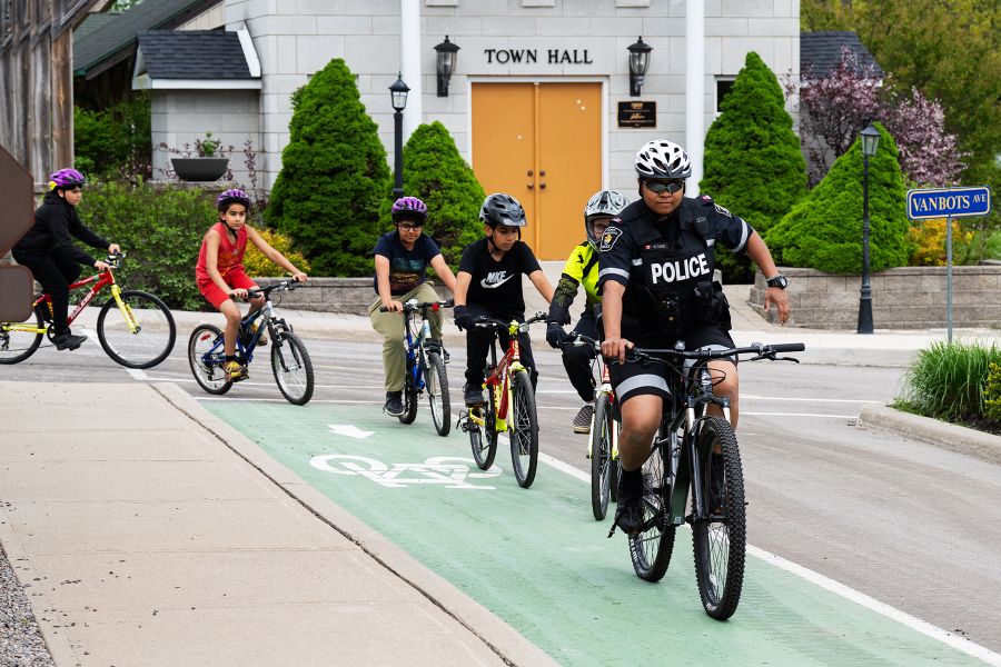 A police officer on a bike is followed in a line by children on bikes