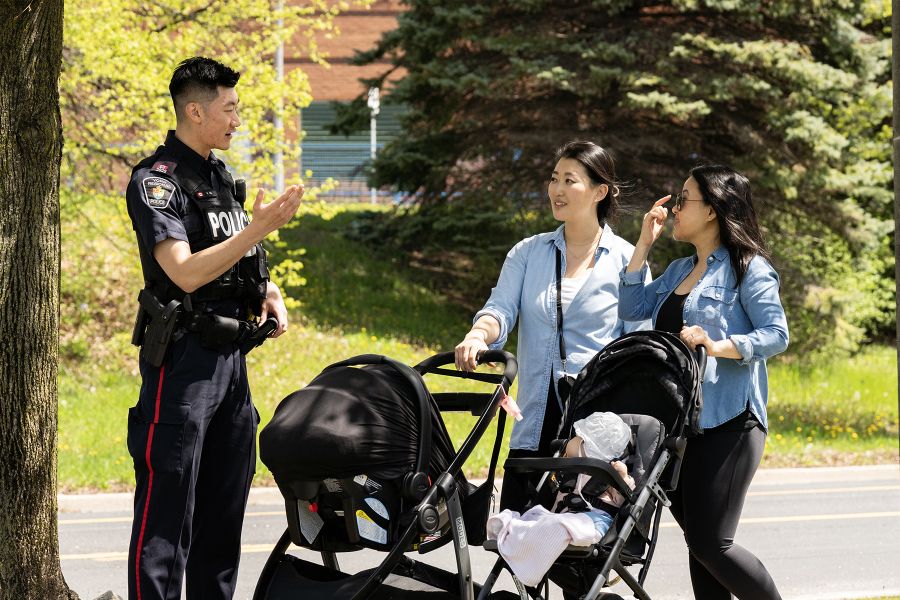 An officer speaks to two women pushing strollers