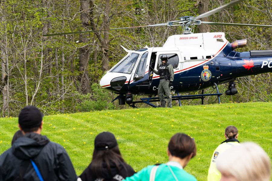 A helicopter on a hill in front of a crowd of people